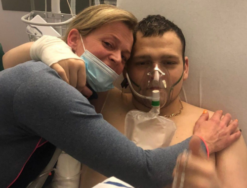 A photo of Leroy and his mother Becky holding each other in his hospital bed.