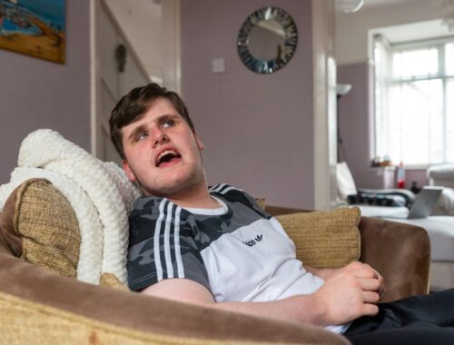 A teenage boy sitting in a comfy armchair