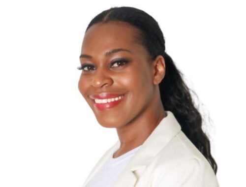 A woman with black hair in a ponytail wearing a white blazer