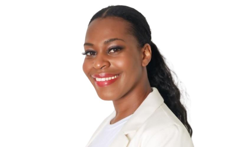 A woman with black hair in a ponytail wearing a white blazer