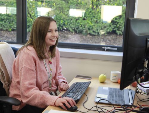 a family fund contact officer looking at her computer screen in an office