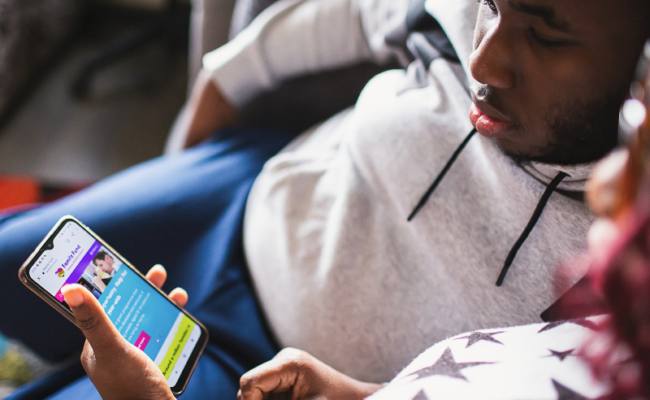 a teenager and his mum looking at the family fund website on a smartphone