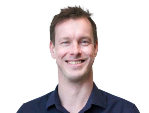 A man with a navy shirt and short dark hair