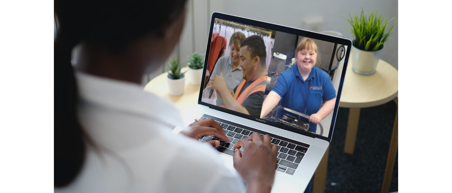 Looking over a woman's shoulder to see photos of young people smiling on her laptop screen