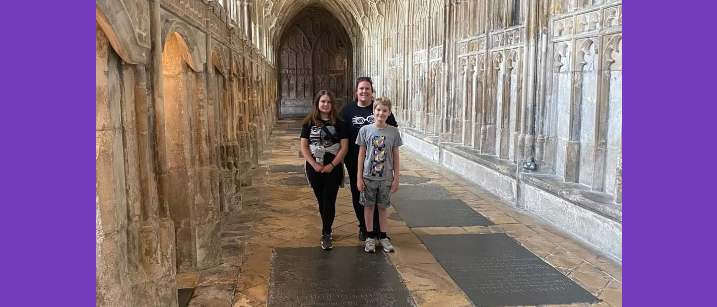 Mum stands with son and daughter in an ornate church corridor